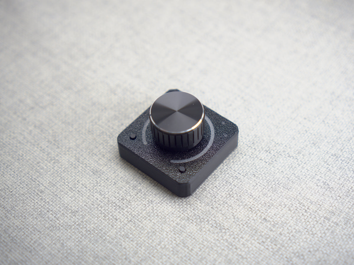 The 1ES2K photographed at an angle on grey fabric, LED ring off