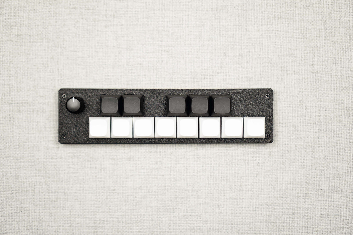 Top-down view of the 13KS-1ES: eight white keys in the front row, five black keys behind, encoder at the far left