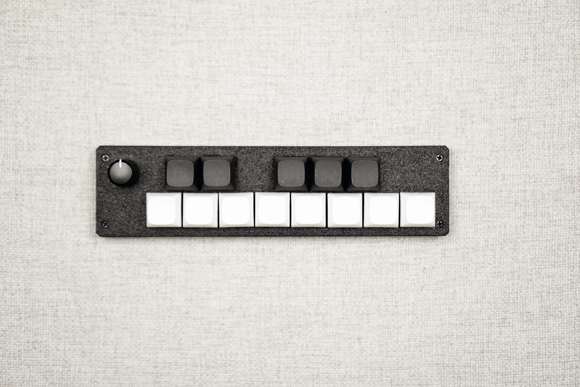Top-down view of the 13KS-1ES: eight white keys in the front row, five black keys behind, encoder at the far left