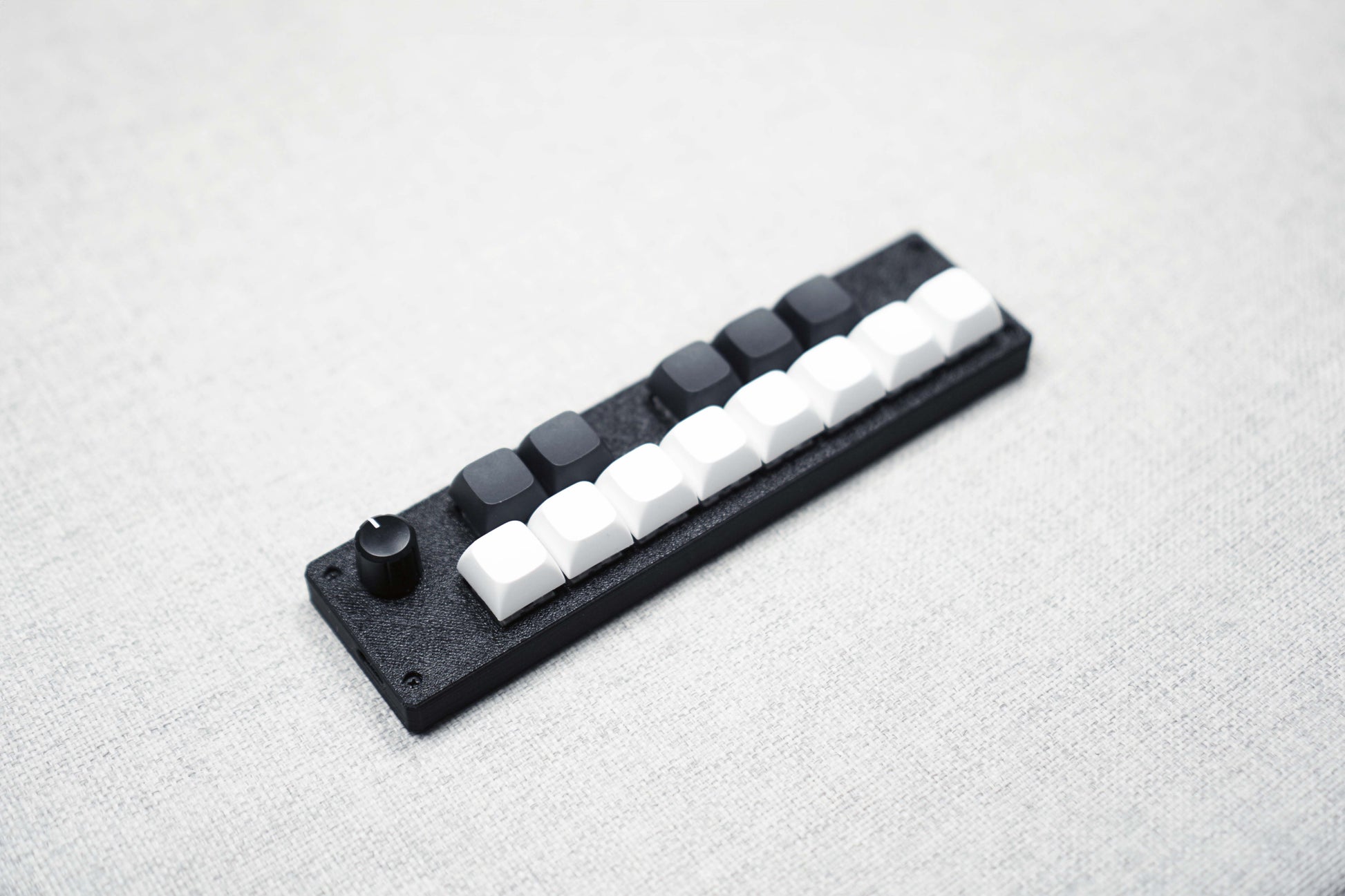 Three-quarter view of the 13KS-1ES from the left, showing the encoder knob and the keycap height